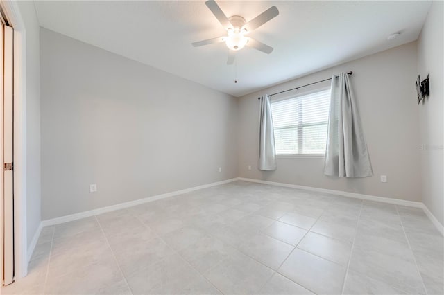 tiled spare room featuring ceiling fan