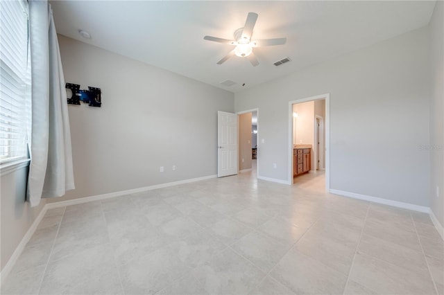 unfurnished bedroom featuring ensuite bathroom, ceiling fan, and light tile patterned flooring