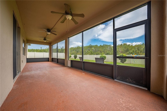 unfurnished sunroom with ceiling fan