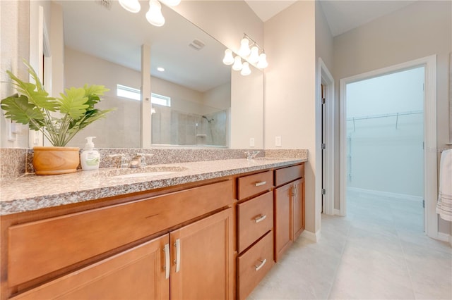 bathroom featuring vanity, tile patterned floors, and walk in shower