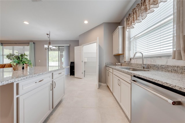 kitchen featuring an inviting chandelier, sink, hanging light fixtures, stainless steel dishwasher, and light stone countertops