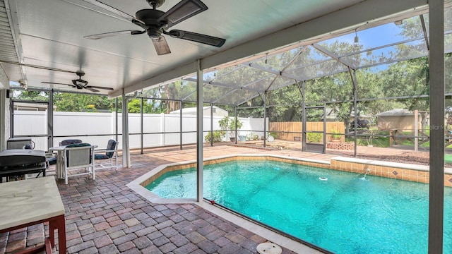 view of pool with a grill, a lanai, a patio area, pool water feature, and ceiling fan