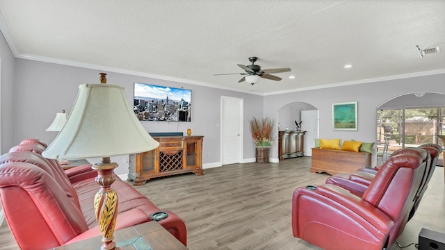 living room with ornamental molding, a textured ceiling, hardwood / wood-style flooring, and ceiling fan