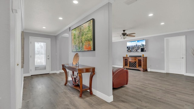 entrance foyer with ceiling fan, hardwood / wood-style flooring, and crown molding