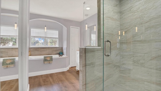 bathroom featuring wood-type flooring and separate shower and tub