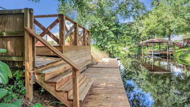 wooden deck with a water view and a dock