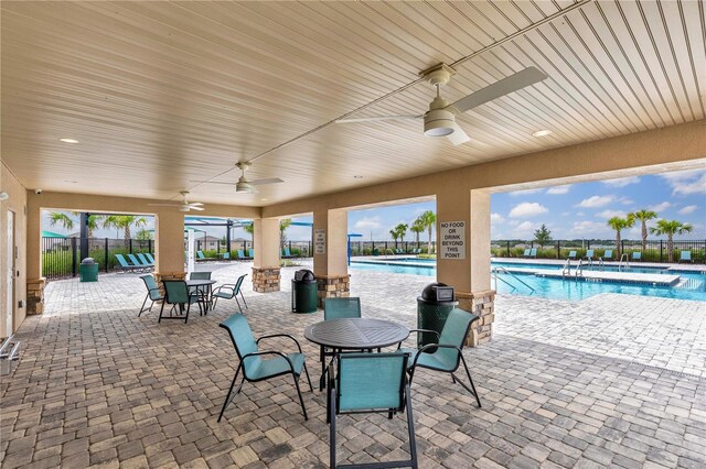 view of patio with ceiling fan and a community pool