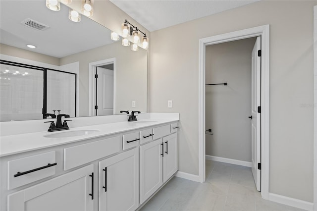 bathroom featuring tile patterned flooring, vanity, and a shower with door