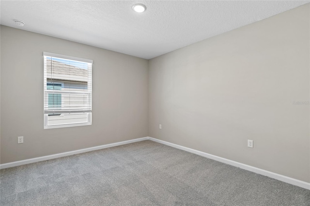 spare room with a textured ceiling and carpet floors