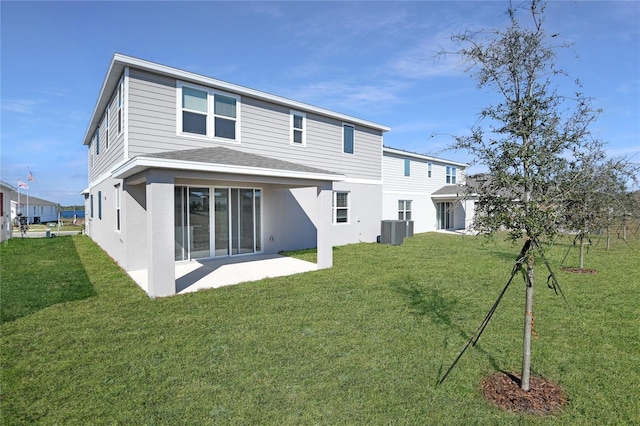 rear view of house with a lawn, cooling unit, and a patio area