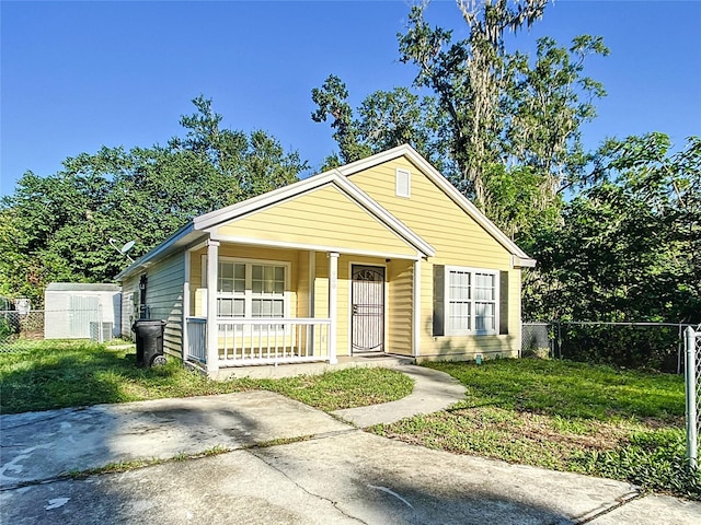 bungalow-style house with a front lawn and covered porch