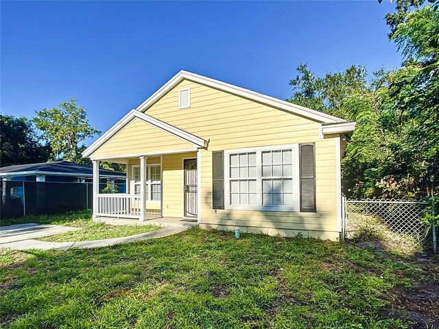 view of front of home with a porch and a front yard