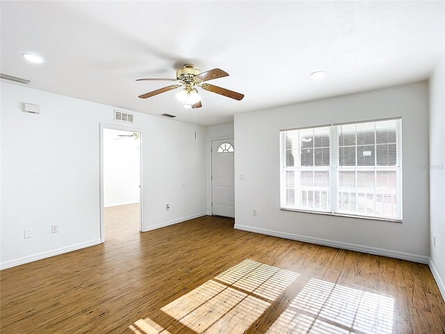 spare room with light wood-type flooring and ceiling fan