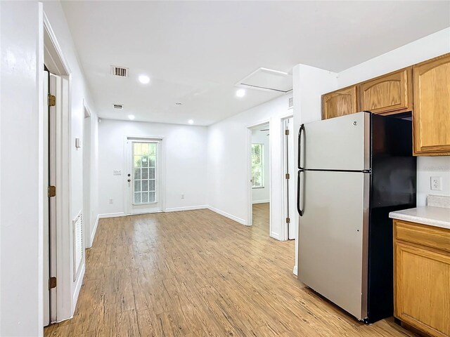 kitchen with stainless steel fridge and light hardwood / wood-style flooring