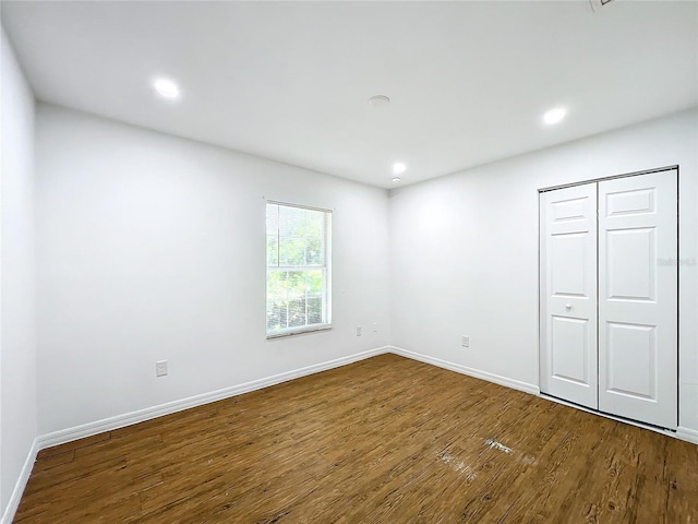 unfurnished bedroom with wood-type flooring and a closet