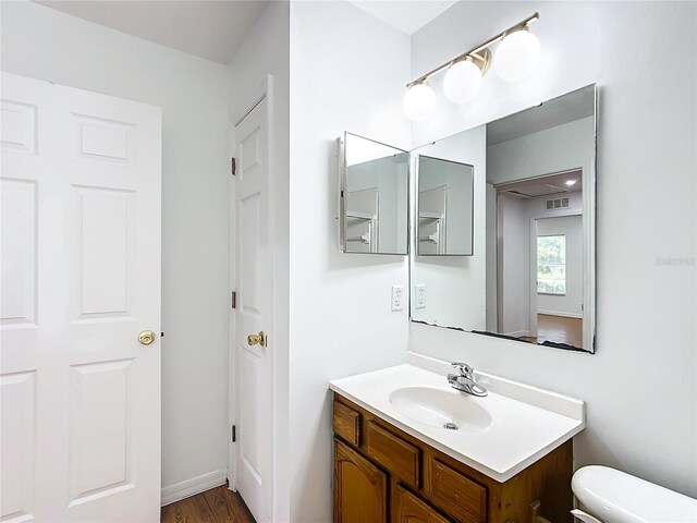 bathroom featuring vanity, toilet, and wood-type flooring