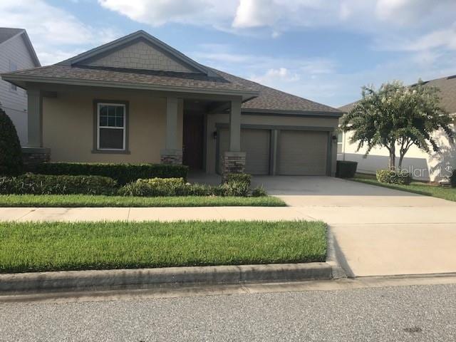 view of front of home featuring an attached garage, driveway, and stucco siding