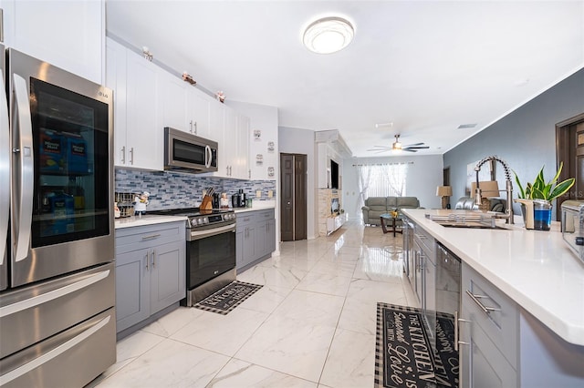 kitchen with gray cabinets, sink, ceiling fan, appliances with stainless steel finishes, and white cabinets