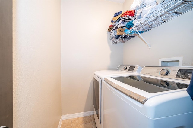 laundry area featuring light tile patterned floors and washing machine and dryer