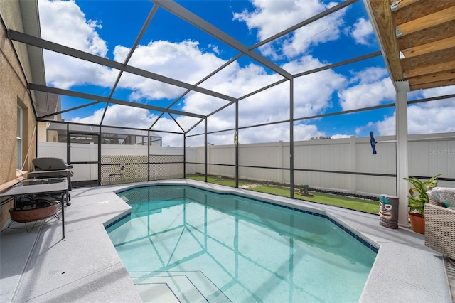 view of pool with glass enclosure and a patio area