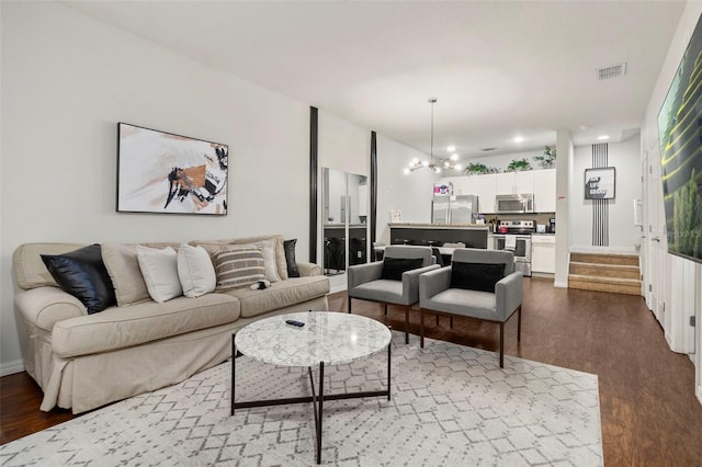 living room featuring an inviting chandelier and hardwood / wood-style flooring