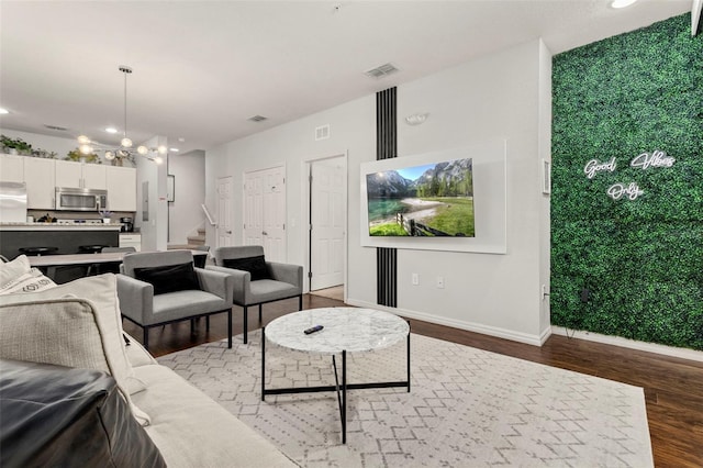 living room featuring an inviting chandelier and hardwood / wood-style floors