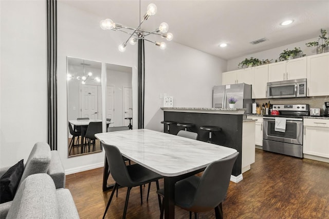 kitchen featuring an inviting chandelier, dark hardwood / wood-style flooring, stainless steel appliances, and white cabinets