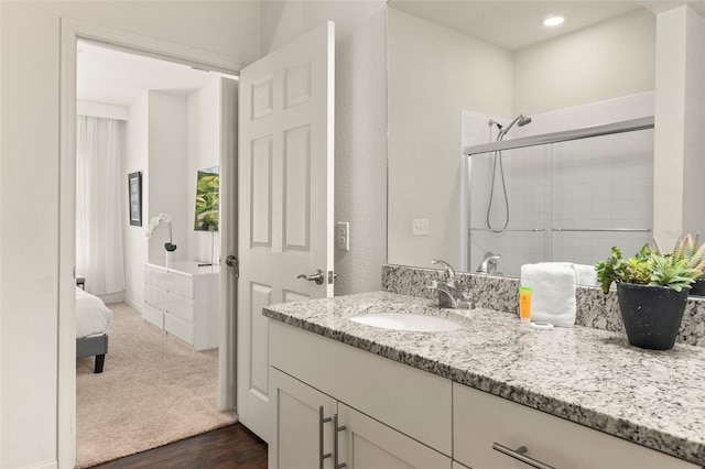 bathroom with an enclosed shower, hardwood / wood-style flooring, and vanity