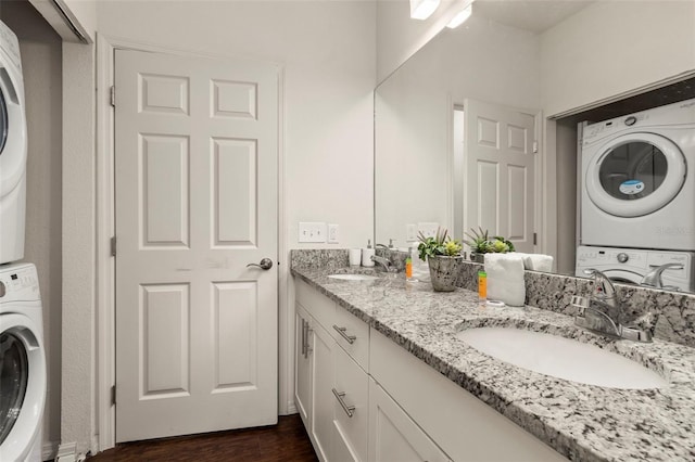 8968 Silver Pl, Kissimmee, FL 34747 - laundry room with stacked washing machine and dryer, a sink, and dark wood-type flooring
