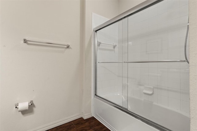 bathroom featuring hardwood / wood-style floors and combined bath / shower with glass door