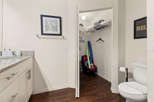 8968 Silver Pl, Kissimmee, FL 34747 - bathroom featuring wood finished floors, vanity, baseboards, and toilet