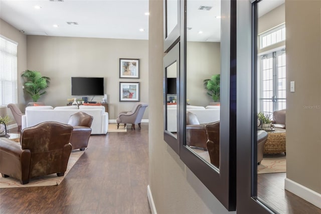 living room with a wealth of natural light and dark hardwood / wood-style flooring