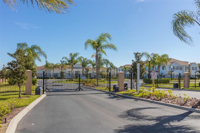8968 Silver Pl, Kissimmee, FL 34747 - view of asphalt road featuring a residential view, a gated entry, a gate, and curbs
