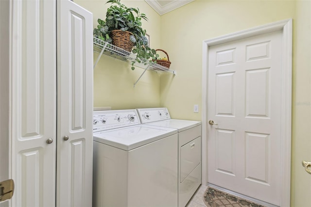 laundry area featuring light tile patterned floors, ornamental molding, and washer and dryer