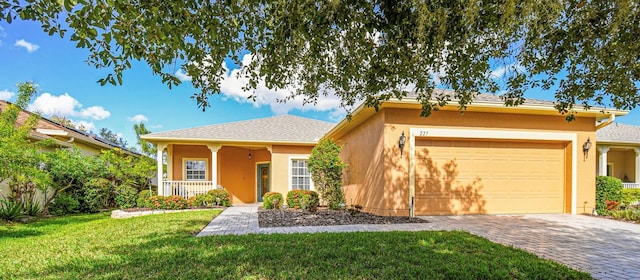 single story home featuring a front yard, a garage, and a porch