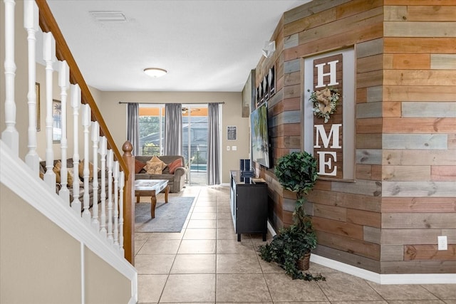 interior space featuring wooden walls and light tile patterned floors