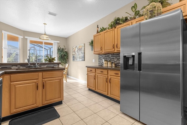 kitchen featuring sink, hanging light fixtures, decorative backsplash, light tile patterned floors, and appliances with stainless steel finishes