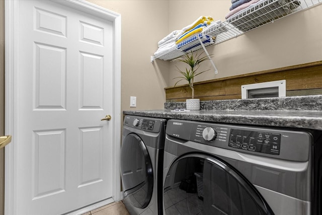 laundry room with separate washer and dryer and tile patterned flooring