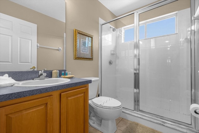 bathroom with toilet, vanity, tile patterned floors, and a shower with shower door