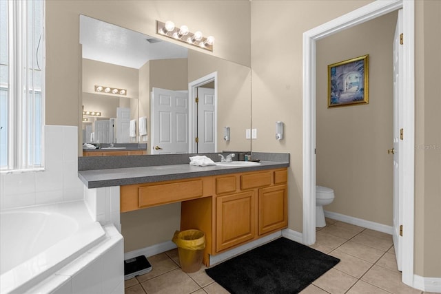 bathroom with tile patterned floors, vanity, tiled bath, and toilet