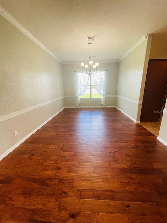 empty room with ornamental molding, dark hardwood / wood-style floors, and a notable chandelier