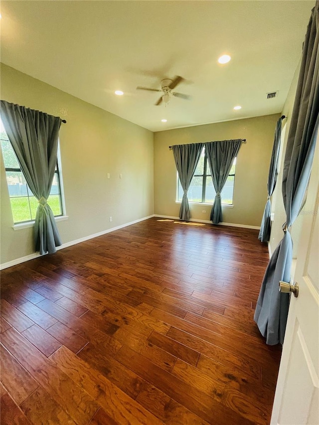 unfurnished room with ceiling fan, dark hardwood / wood-style flooring, and a healthy amount of sunlight