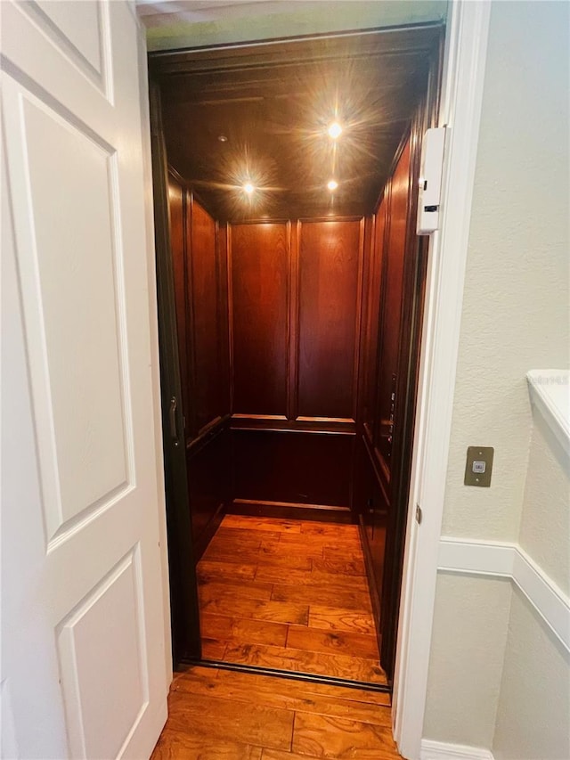 details featuring elevator and hardwood / wood-style floors