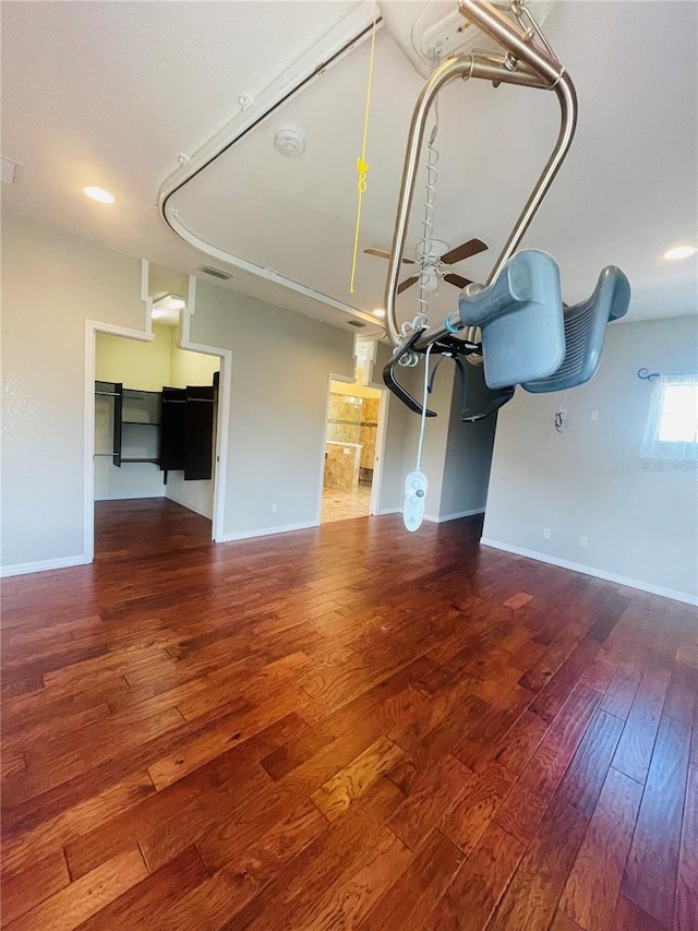 unfurnished living room featuring ceiling fan and hardwood / wood-style flooring