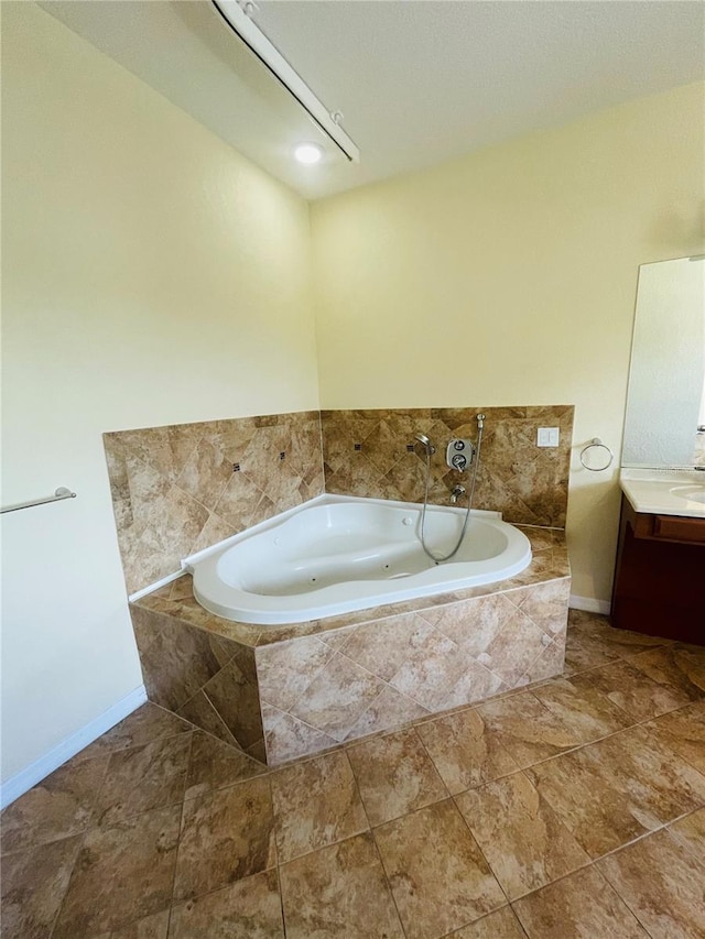 bathroom featuring tiled tub and vanity