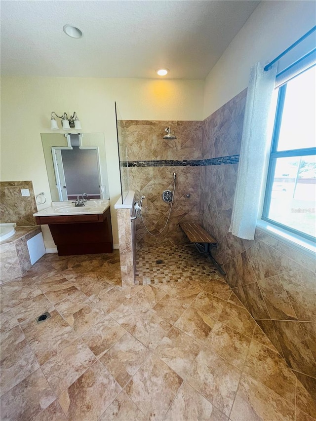 bathroom featuring a wealth of natural light, shower with separate bathtub, and vanity