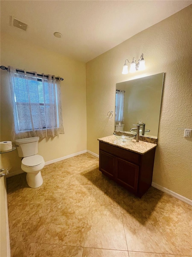 bathroom featuring vanity, toilet, and tile patterned flooring