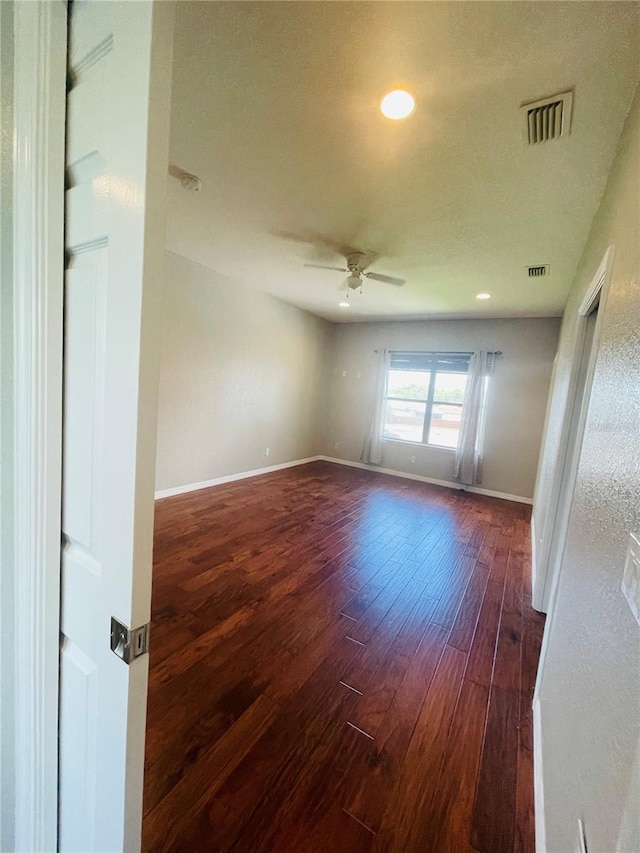 empty room featuring ceiling fan and dark hardwood / wood-style floors