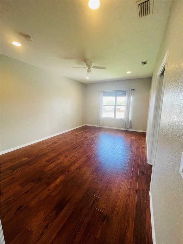 spare room featuring dark hardwood / wood-style flooring and ceiling fan