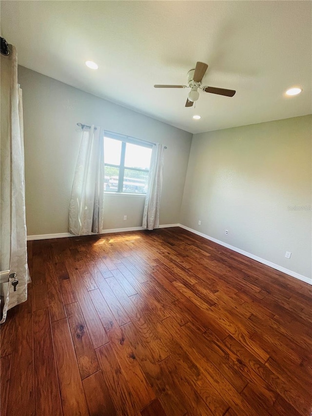 spare room featuring ceiling fan and dark hardwood / wood-style floors